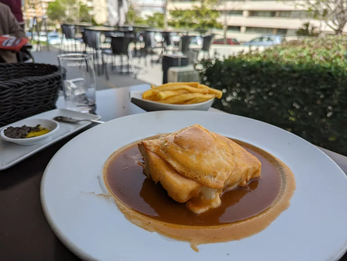Francesinha with egg and fries, the signature dish of a Porto food tour