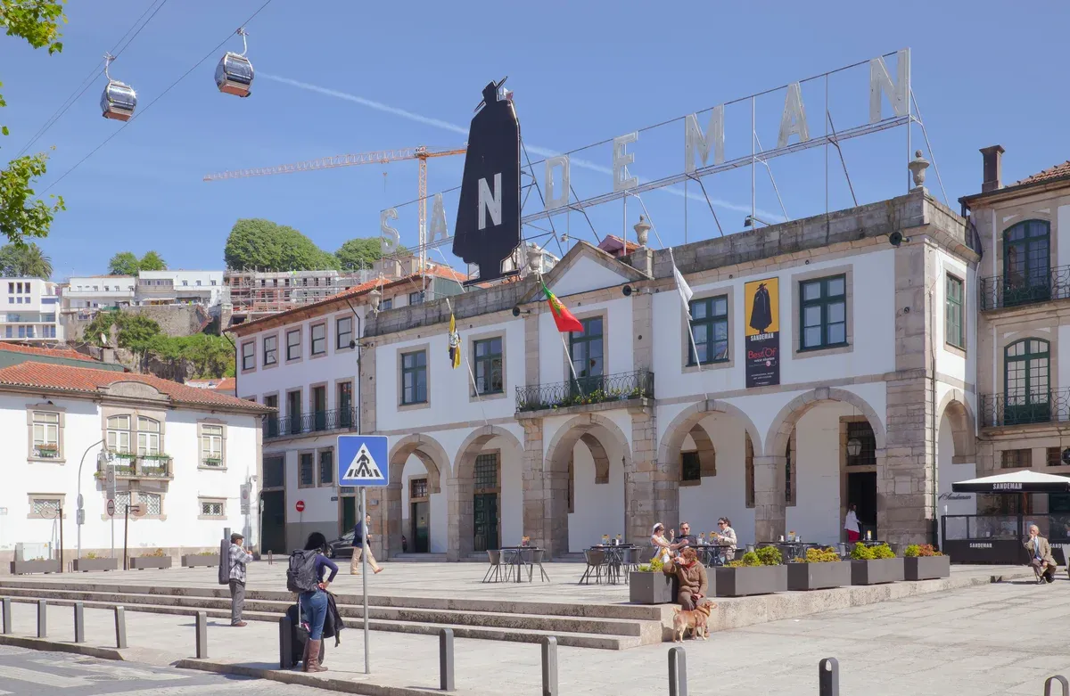 The Sandeman lodge and its cloaked Don figure on the Gaia riverside, a stop for port wine tours in Porto